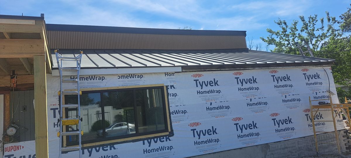 Standing-seam metal roof installed above walls wrapped in Tyvek HomeWrap