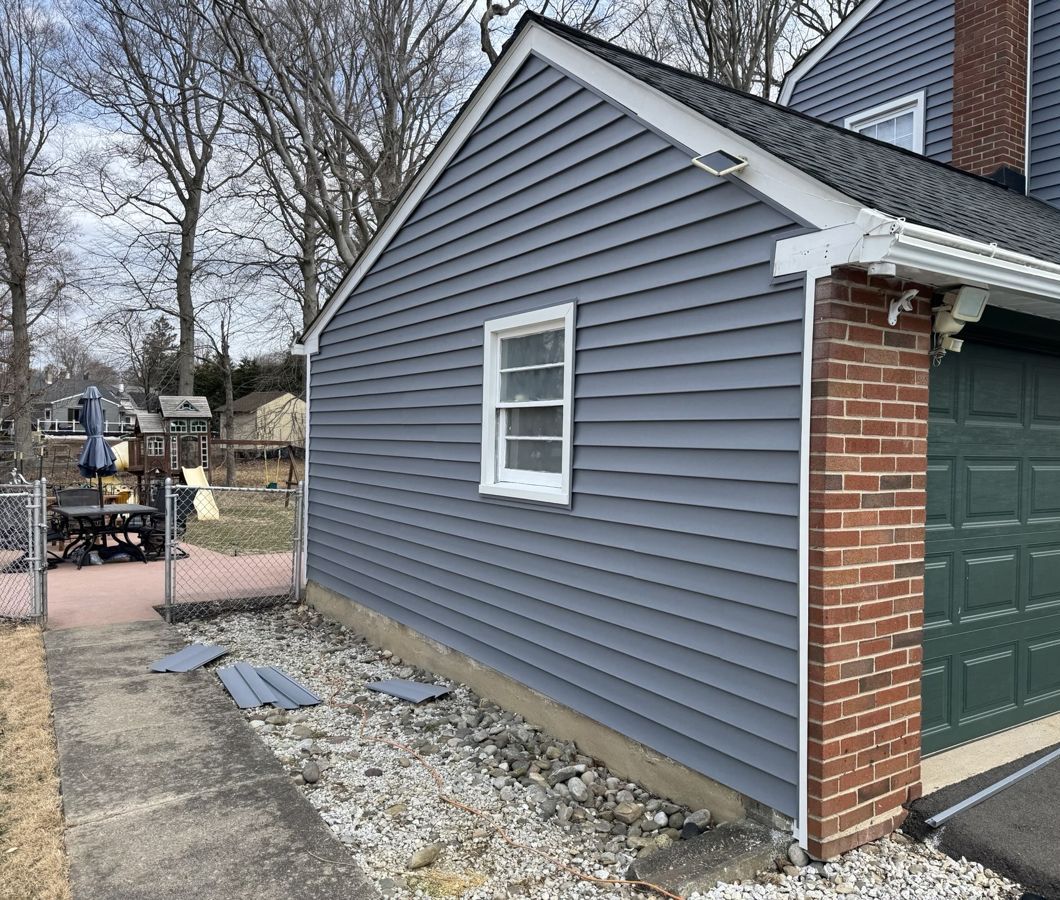 Gray-blue vinyl siding, white trim and a charcoal shingle roof on a garage in Feasterville