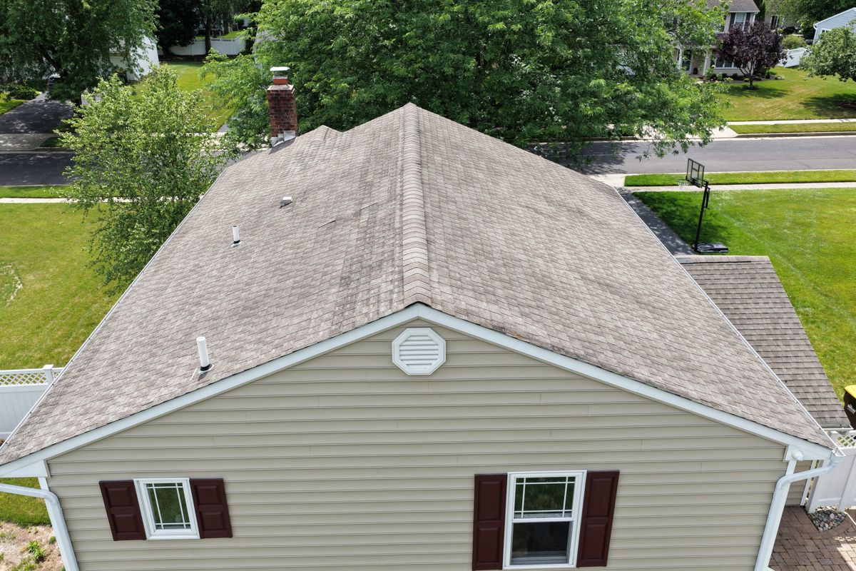Streaked, worn asphalt shingles on a Newtown home before roof replacement