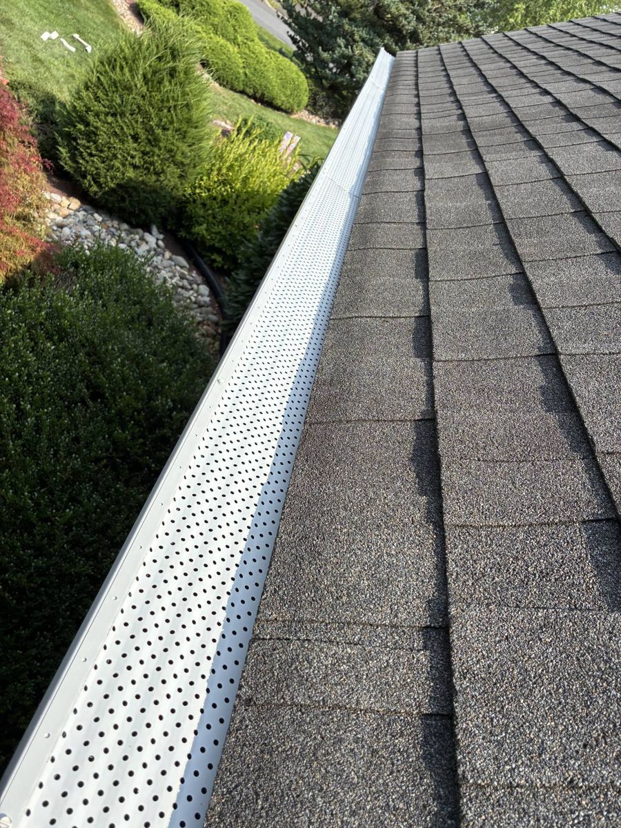 White perforated gutter guard installed on a new gutter in Newtown