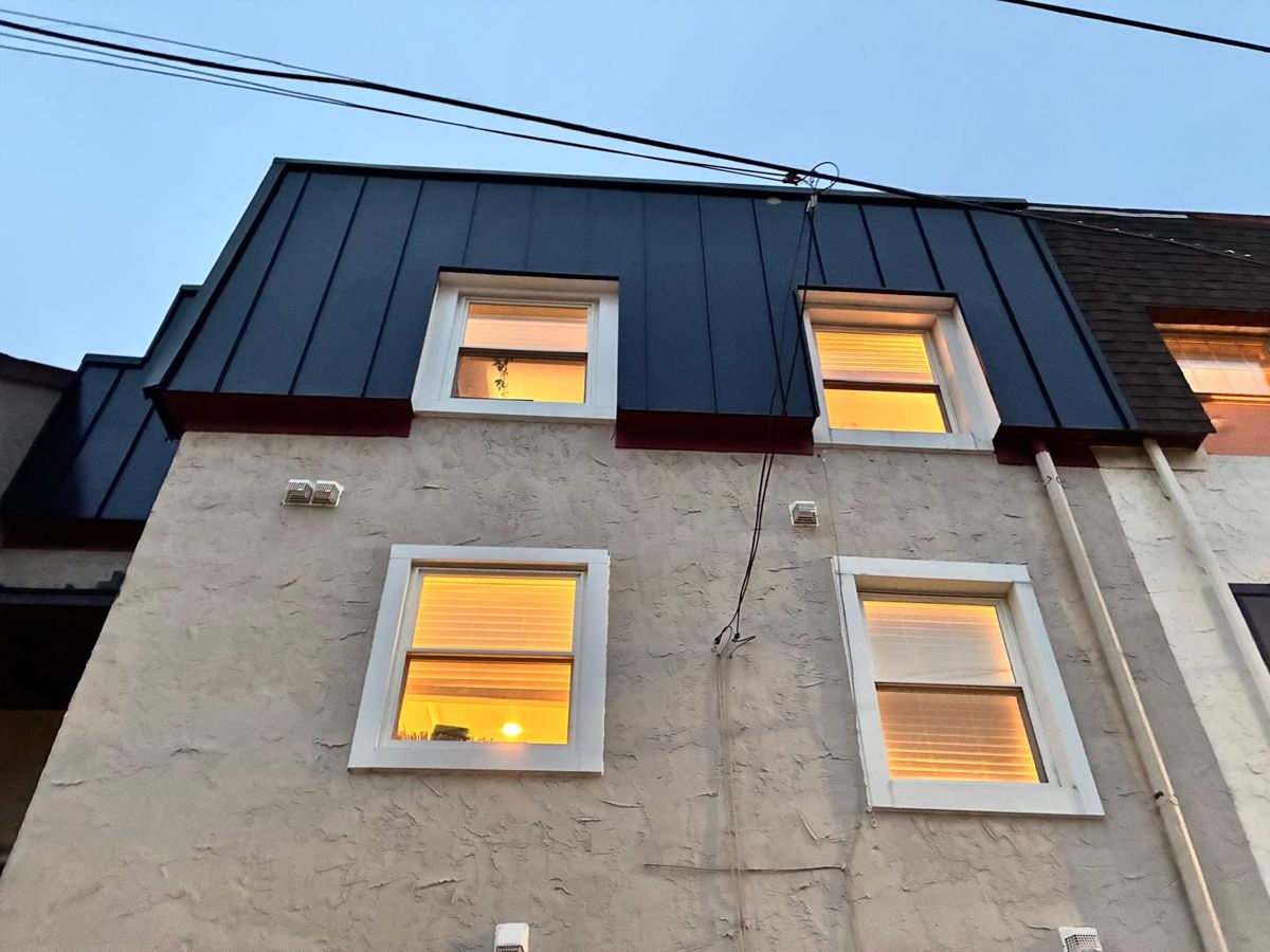 Rowhome with a new matte-black standing-seam metal mansard and dormer windows in Philadelphia